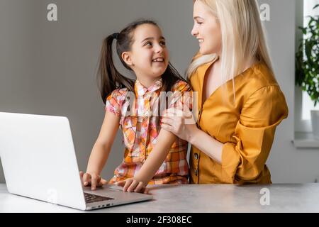 Helpful mother explaining to daughter about using a laptop Stock Photo