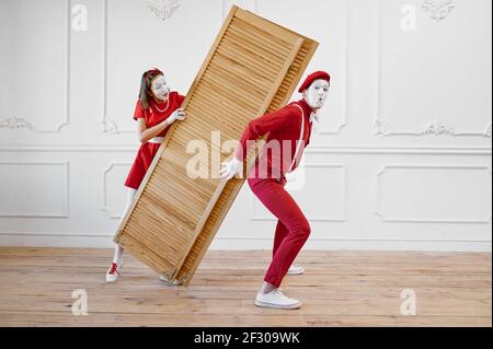 Two mime artists, clowns with wooden partition Stock Photo
