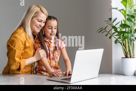 Helpful mother explaining to daughter about using a laptop Stock Photo