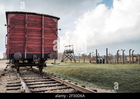 Auschwitz Birkenau II Concentration Extermination Camp Oswiecim Single red train railway carriage wooden tracks holocaust lookout guard tower sorting Stock Photo