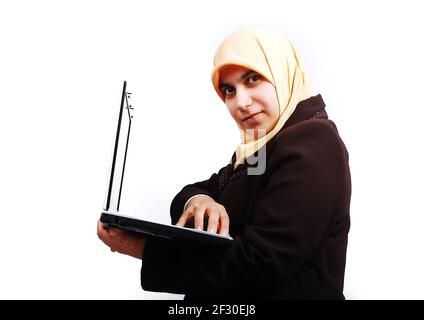 Young muslim female in traditional clothes with laptop Stock Photo