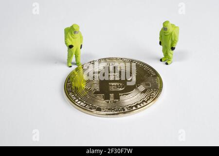 macro figures lookking on bitcoin. virtual cryptocurrency mining concept Stock Photo