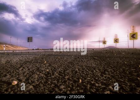A asphalt road above a purple cloudy sky Stock Photo - Alamy