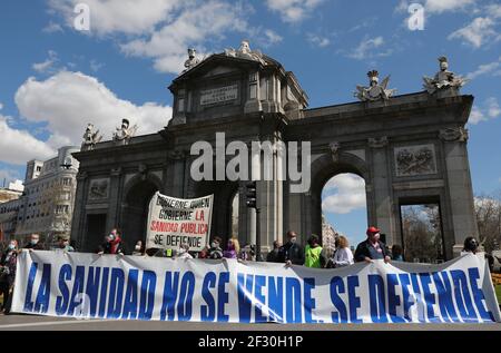 Madrid, Spain. 14th March, 2021. Demonstrators from the social movement ‘marea blanca’, or white tide, take part in a protest against the privatisation of the public health and the management of the covid-19 crisis by government at Puerta de Alcalá in Madrid, Spain, on Sunday March 14th, 2021. Credit: Isabel Infantes/Alamy Live News Stock Photo