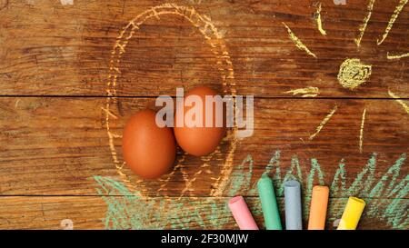 Easter eggs in a basket. Drawing with colored chalk on a wooden background Stock Photo