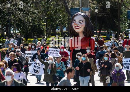 Madrid, Spain. 14th Mar, 2021. Protesters carrying placards and big a figure of regional president of Madrid Isabel Diaz Ayuso with a large nose during a demonstration in support of the public health system. Demonstrators are protesting against the management of the coronavirus (COVID-19) crisis by regional president Isabel Diaz Ayuso and demanding their resignation. Credit: Marcos del Mazo/Alamy Live News Stock Photo