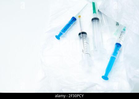 Several disposable syringes of different sizes close-up on a white surface. Selective focus. Medical equipment for intravenous and intramuscular Stock Photo