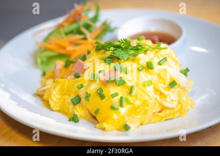 Creamy omelet with bacon on rice in soft focus. Stock Photo