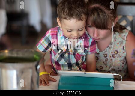 Children using tablet PC in a restaurant Stock Photo