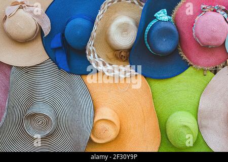A variety of fashionable and colorful hats hanging on the bamboo ...