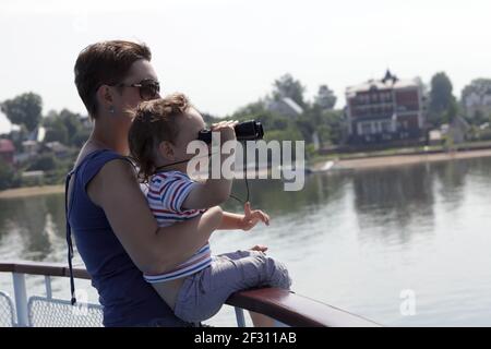 Child looking through binoculars on Volga river Stock Photo