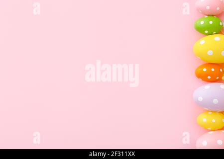 Colorful plastic Easter eggs on a pink background with copy space. Top view Stock Photo