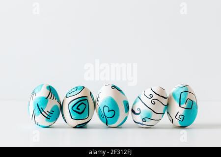 Creative trendy painted easter eggs on white background. Easter ideas. Stock Photo