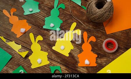Easter bunnies made of paper on a wooden background. Create a decor for easter Stock Photo