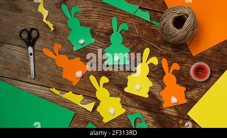 Easter bunnies made of paper on a wooden background. Create a decor for easter Stock Photo