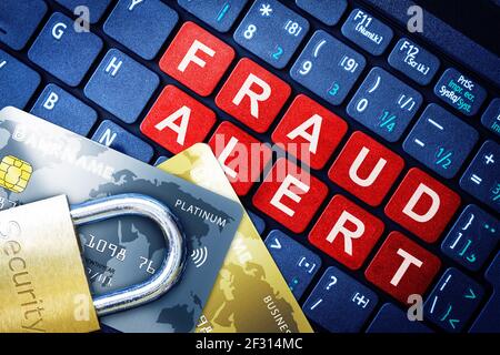 Fraud Alert in red keys on high-tech computer keyboard background with security engraved lock on fake credit cards. Concept of Internet security, data Stock Photo