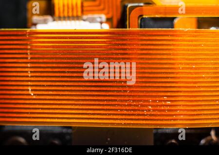 Board-to-board electronic loop of bright orange color for transferring information between electronic chips close-up, macro shooting Stock Photo