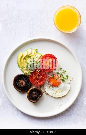 Vegetarian breakfast with fried egg, tomatoes, mushroom and avocado Stock Photo