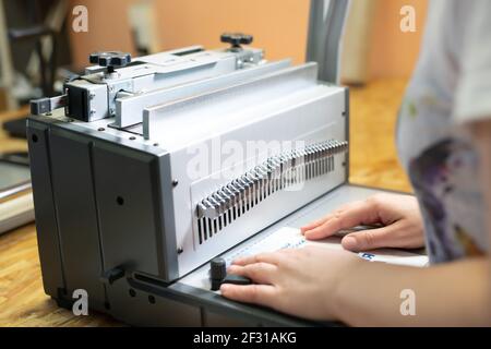 Anonymous woman working on book binding machine Stock Photo