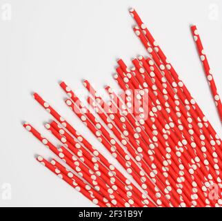 Red paper straws for a cocktail on a white background Stock Photo
