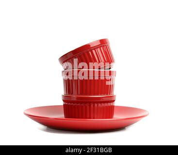 Stack of red ceramic round cupcake baking dishes isolated on white background Stock Photo