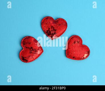 Red textile small hearts on blue background, festive background Stock Photo