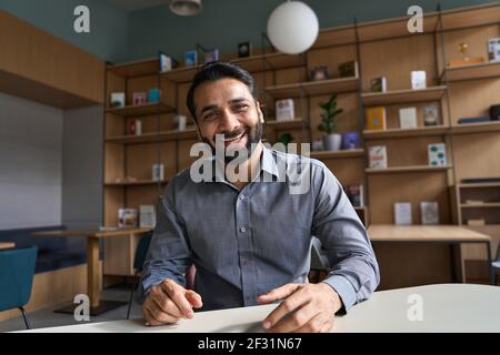 Happy indian business man, teacher talking to web cam on conference video call. Stock Photo