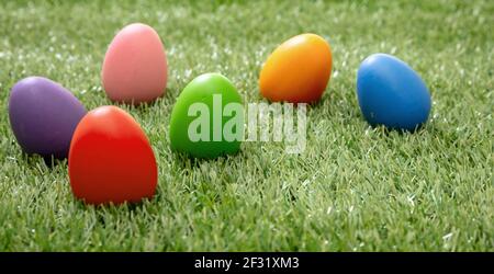 Easter eggs hunt concept. Happy Easter greeting card. Colorful eggs on green grass, outdoors in nature, closeup view. Christian religion holiday celeb Stock Photo