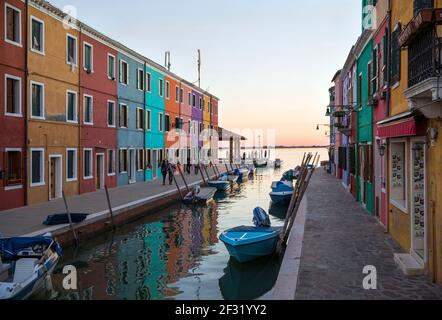 Italy, Venice, Burano, colourful buildings lining a canal. Burano was a fisherman's island and also noted for lace. Stock Photo