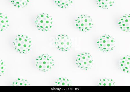 Flat lay with inverted green and white cupcake tins or forms for muffins on white background, isolated. High quality photo Stock Photo