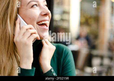 Portrait of blonde girl talking by smartphone. Stock Photo