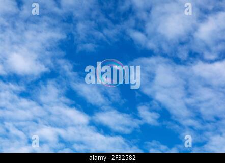 bubble floating up against sky and clouds Stock Photo