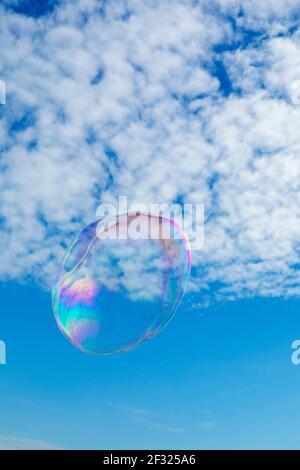 bubble floating up against sky and clouds Stock Photo