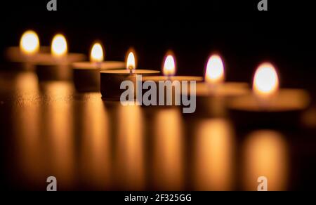 Closeup of many candles burning. The candle light is reflected. Stock Photo