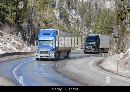 Tumwater Canyon, WA / USA - March 3, 2021:  18 wheeler trucks negotiate a curve on US2 at Tumwater Canyon near Leavenworth on March 3, 2021 Stock Photo