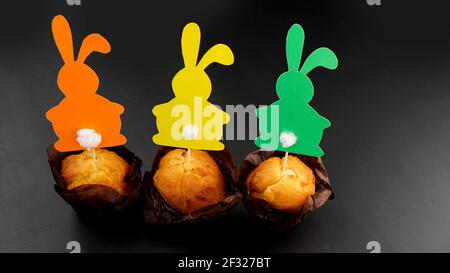 Muffin decorated with a paper rabbit on a toothpick. Easter decor for cupcakes Stock Photo