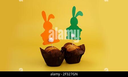 Muffin decorated with a paper rabbit on a toothpick. Easter decor for cupcakes Stock Photo