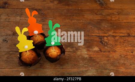 Muffin decorated with a paper rabbit on a toothpick. Easter decor for cupcakes Stock Photo