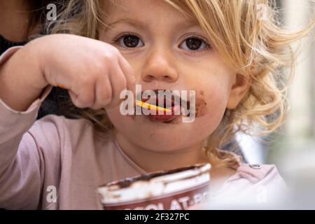 Baby girl eating chocolate icecream Stock Photo