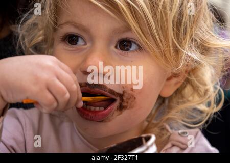 Baby girl eating chocolate icecream Stock Photo