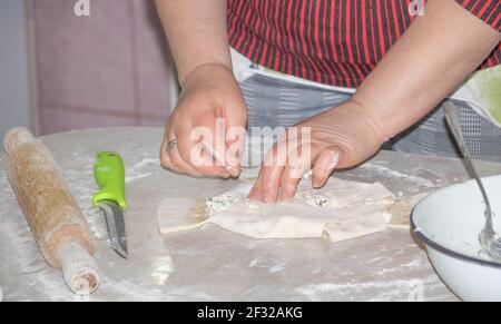 In the process of cooking cheese pies - women hands working with dough. Stock Photo