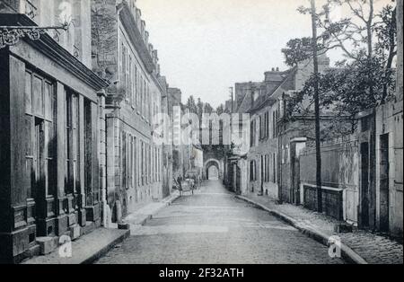 A historical view of the Rue de L'Ecole and the gateway to St. Malo port in Dinan, Côtes-d'Armor, Brittany, France, taken from a postcard c. early 1900s. Stock Photo
