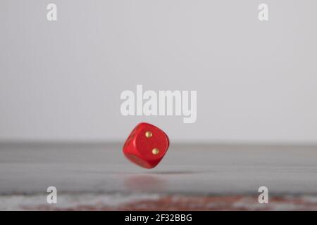 the die is cast, red dice falling on a gray wooden board Stock Photo