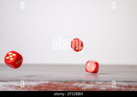 the die is cast, red dice falling on a gray wooden board Stock Photo