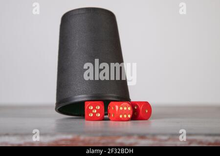 mug with three red dices on a grey wooden board Stock Photo