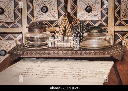 Very old inkwell next to original 16th century manuscript Stock Photo