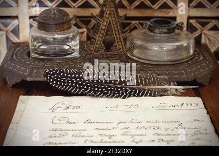 Very old inkwell and quill pen next to original 16th century manuscript Stock Photo