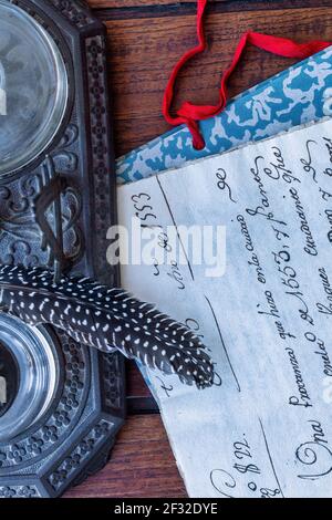 Inkwell, quill, file folder and very old manuscripts on wooden table Stock Photo