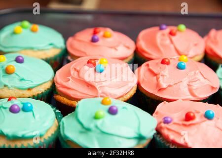 eautifully frosted colorful cupcakes with candies on top Stock Photo