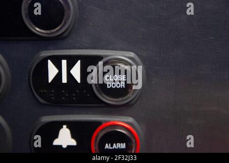 Close view of an elevator button to close the steel door and also elevator alarm button Stock Photo